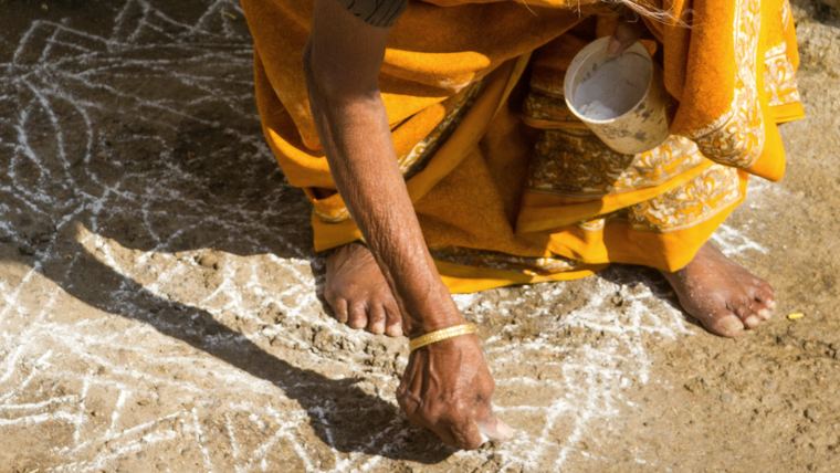 A grandmother drawing kolam at her doorstep in Chennai